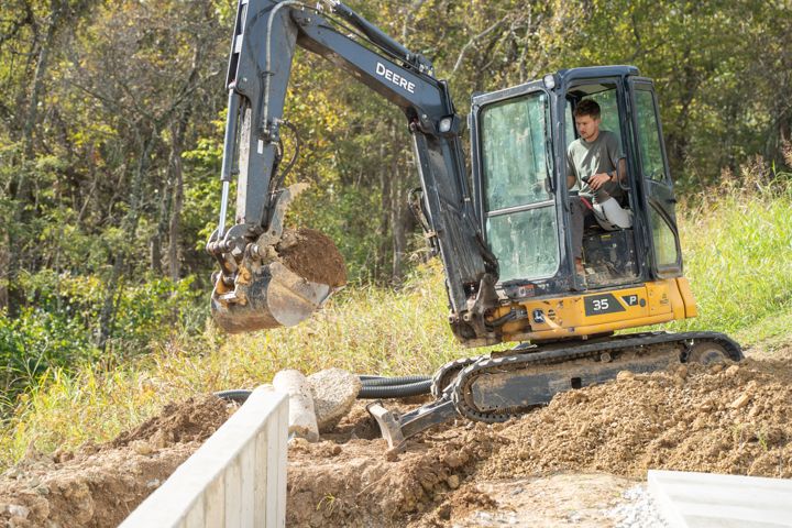 Excavator working beside a structure